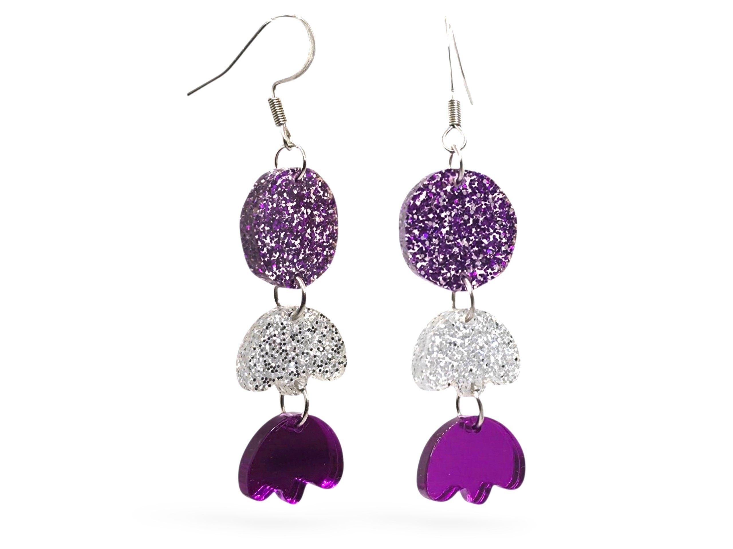Doris | Puiset korvakorut | Korvakorut | Koruliike Auros Kotimainen verkkokauppa Purple glitter circular earrings on silver hooks hanging against a white background | Puiset korvakorut | Korvakorut | Koruliike Auros Kotimainen verkkokauppa